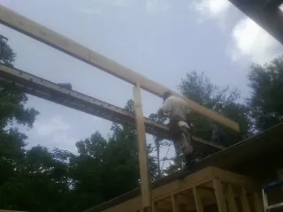 Carpenter setting a ridge beam over a new addition frame — Ice Dam Removal by Roofing Brothers in Five Points