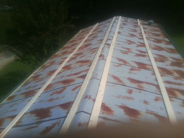 Rusted metal roof panels with new wood purlins before replacement — Storm Damage Roof Repair in Five Points by Roofing Brothers