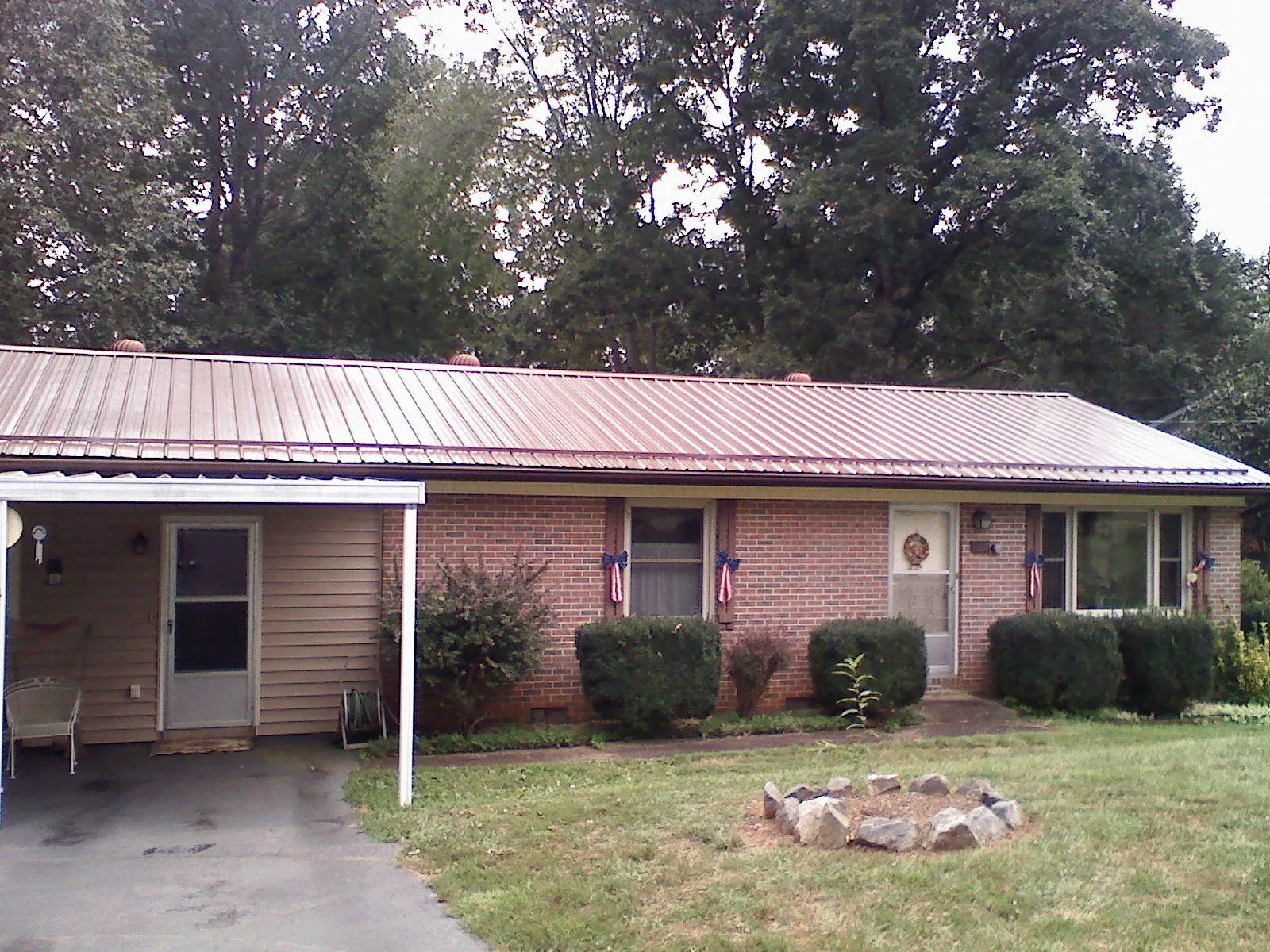Bronze metal roof and carport on a brick ranch home — Roof Repair work by our crew in Five Points